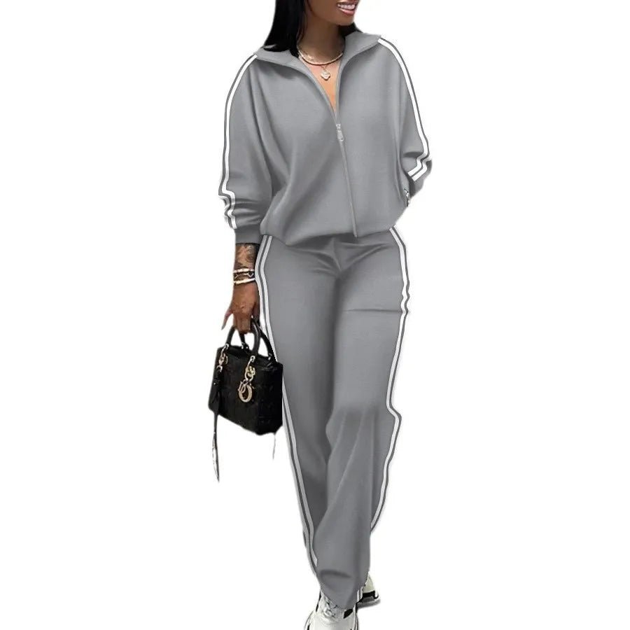 Woman wearing a gray tracksuit with white stripes on a white background