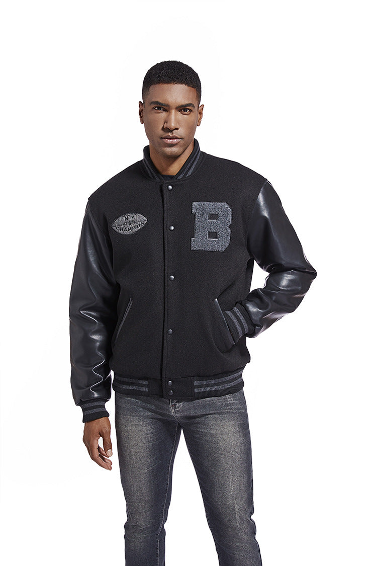 Man wearing a black varsity jacket with leather sleeves on a white background