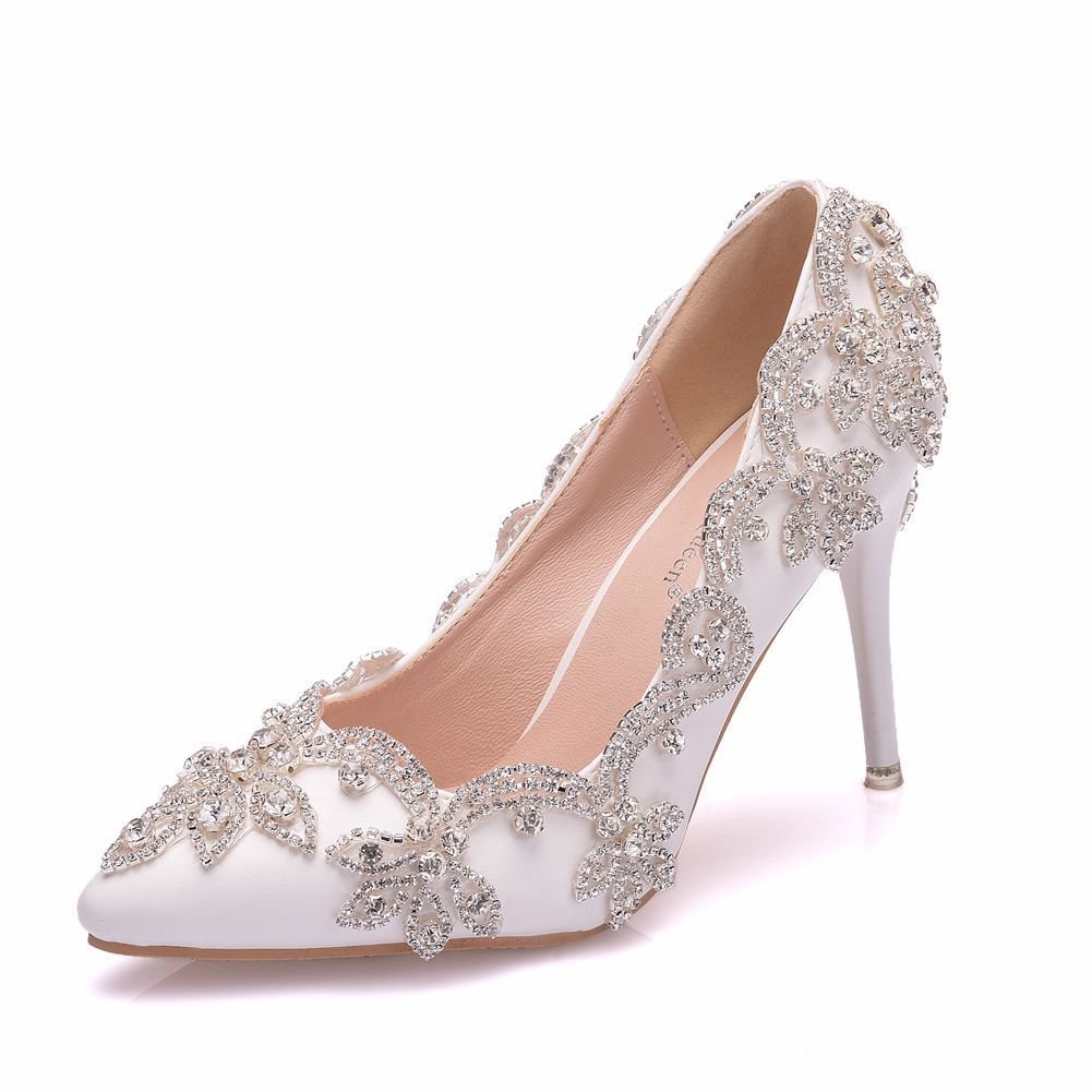 White high-heeled shoe with silver embellishments on a white background