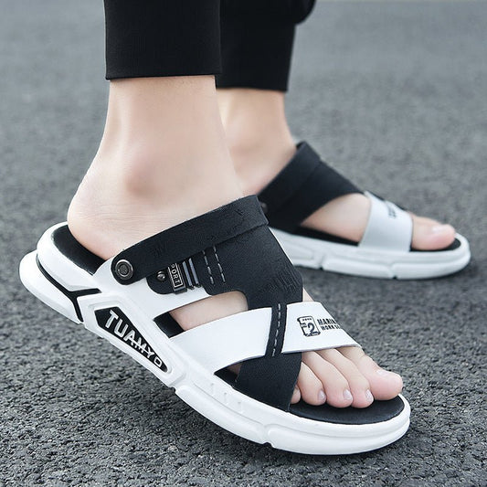 Black and white sandals worn on feet standing on a gray surface