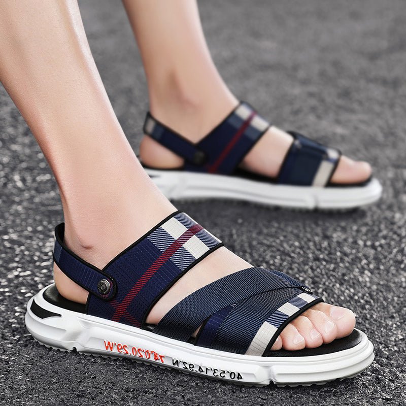 Navy blue and white sandals with plaid pattern worn on a gray surface