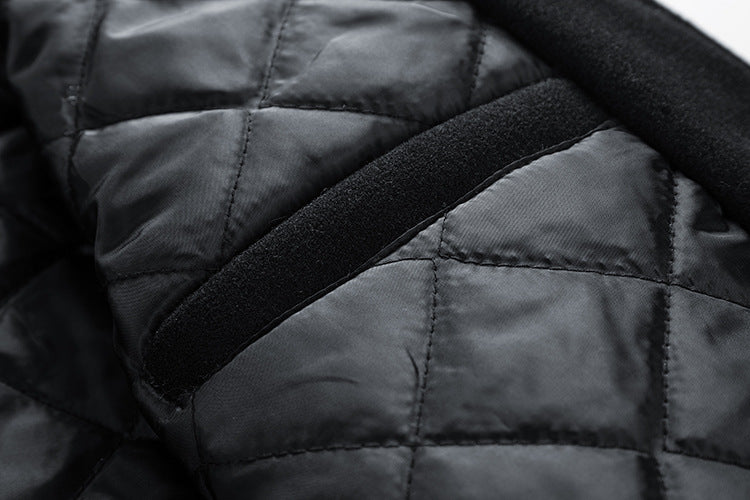 Close-up of a dark gray quilted jacket with a black strap.