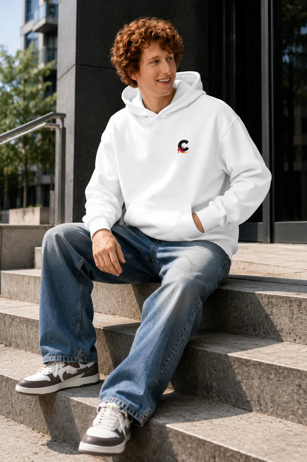 Young man wearing a white unisex streetwear logo hoodie by Casual Flow Shop
